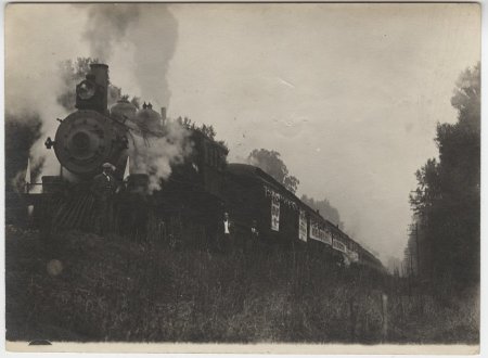 Man in front of steaming train.