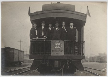 Men in suits standing on a train, Arkansas on Wheels