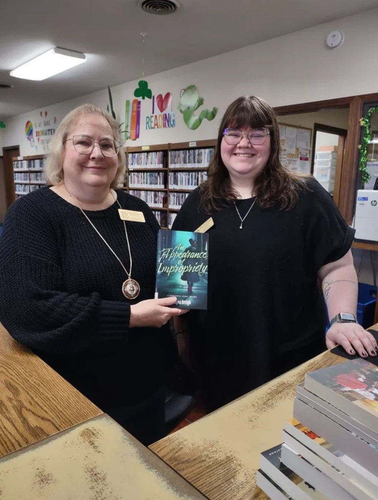 Photo of Dover library staff holding a book.